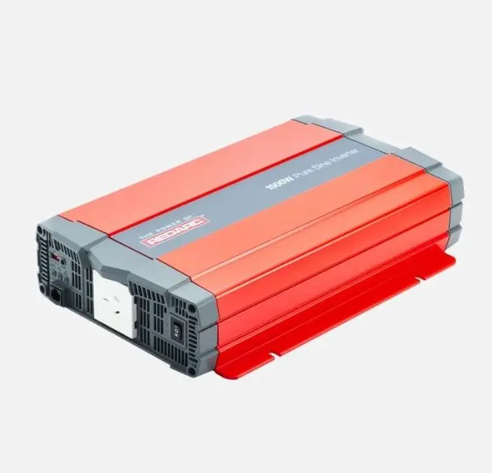 A red and gray power inverter is on the ground