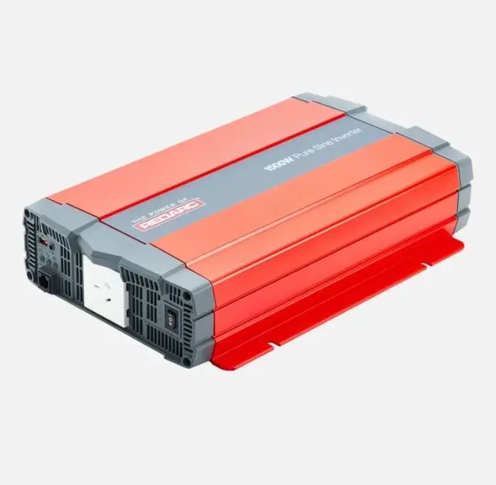 A red and gray power inverter is on the ground.