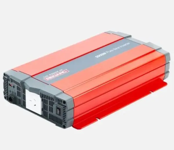 A red and gray power inverter is on the ground.