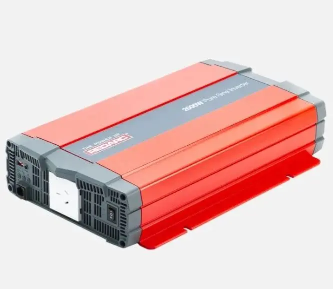 A red and gray power inverter is on the ground.