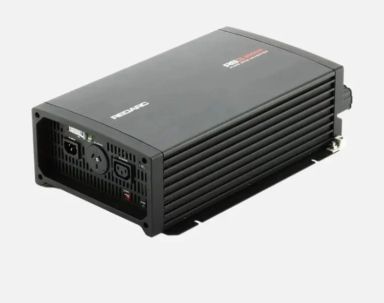 A black power inverter is sitting on top of the floor.