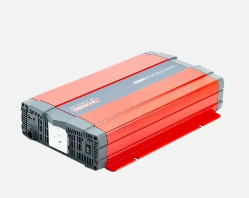 A red and gray power inverter is on the ground.