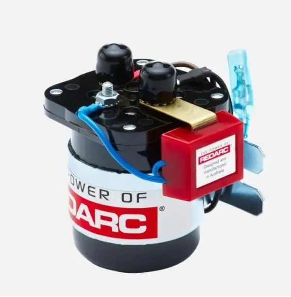 A small red and black motor is on the side of a white wall.