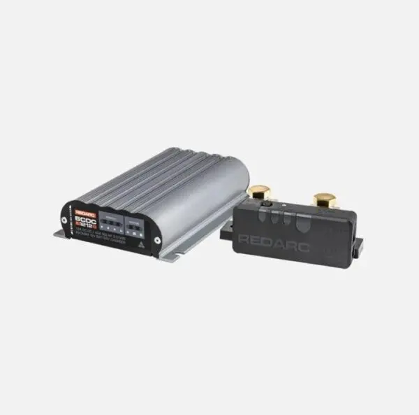 A silver and black device is next to a battery.