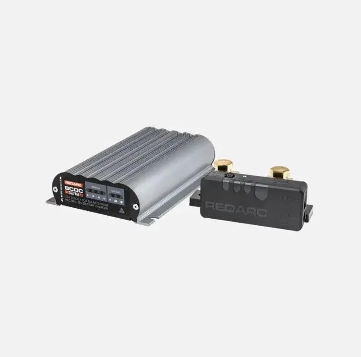 A silver and black device is next to a battery.