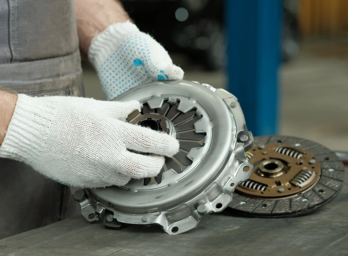 A person holding an engine clutch on top of a table.